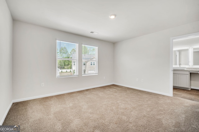 interior space with visible vents, baseboards, and light colored carpet