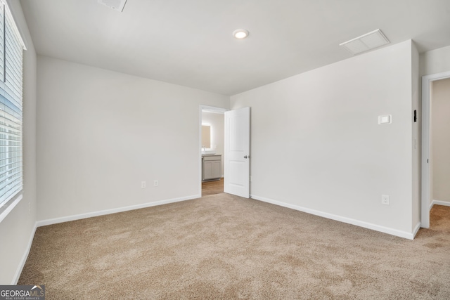 unfurnished bedroom with carpet, visible vents, and baseboards