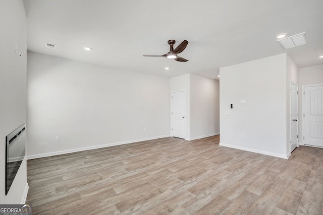 unfurnished living room with light wood-type flooring, baseboards, and recessed lighting