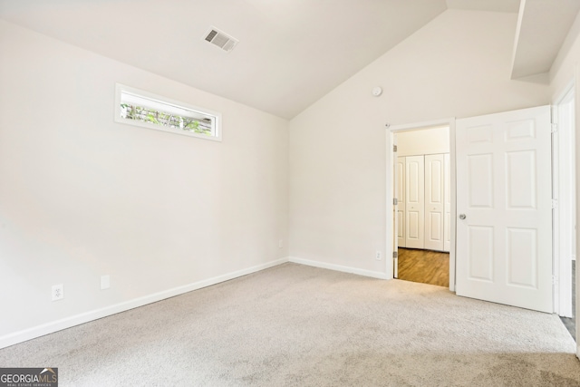 unfurnished bedroom with carpet and high vaulted ceiling