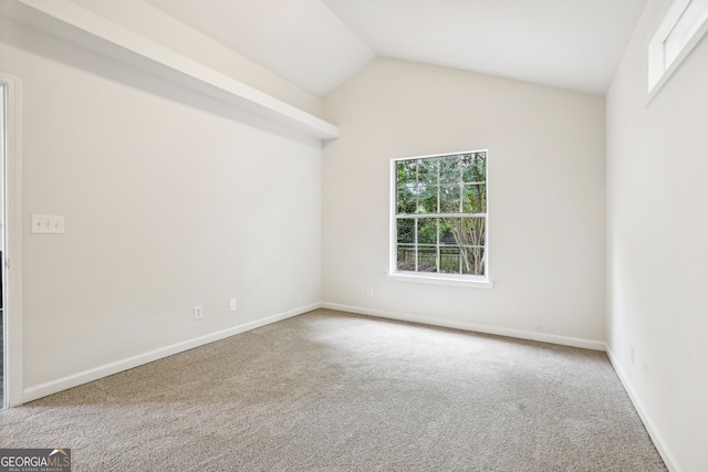 carpeted spare room with lofted ceiling