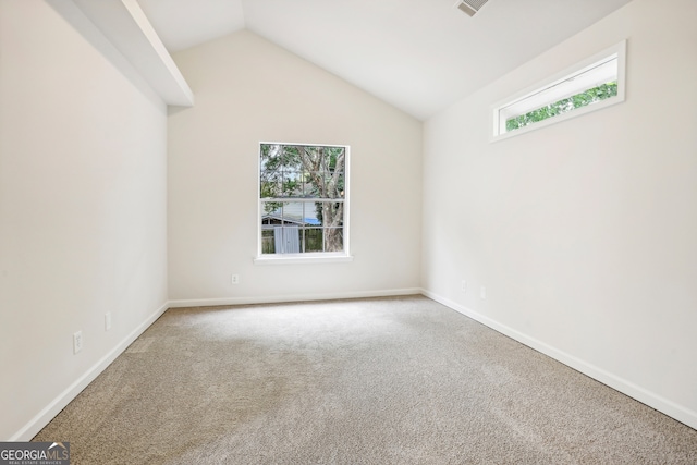 spare room featuring carpet and lofted ceiling