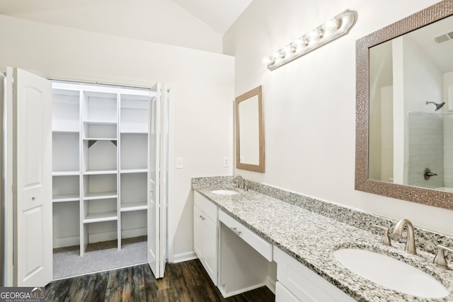 bathroom with wood-type flooring, vanity, lofted ceiling, and walk in shower