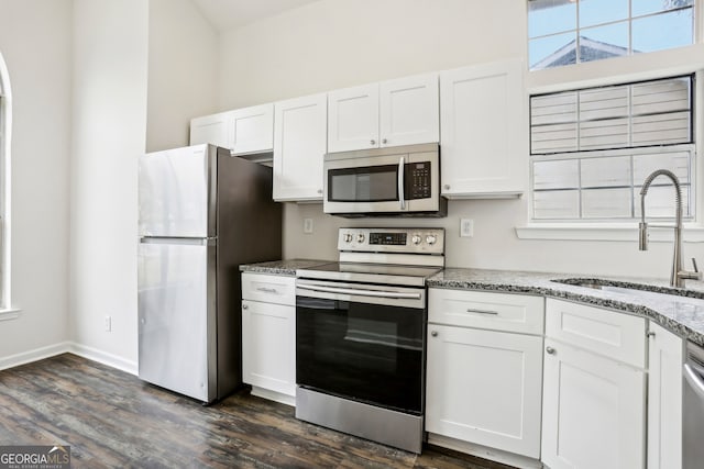 kitchen with white cabinets, appliances with stainless steel finishes, and dark hardwood / wood-style flooring