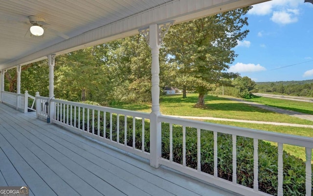 wooden terrace featuring a yard and a porch