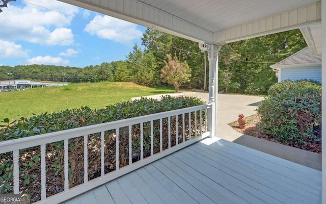 wooden terrace featuring a lawn and a water view