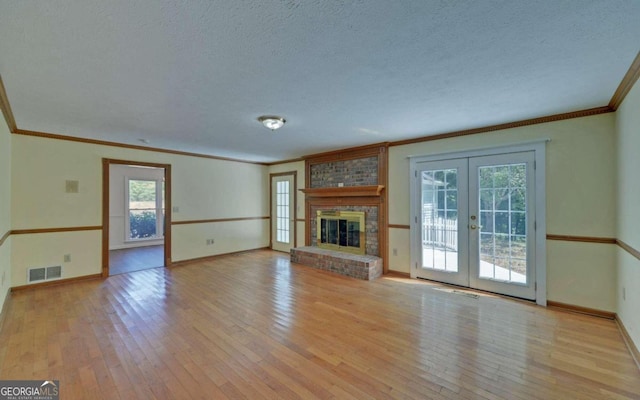 unfurnished living room with a textured ceiling, light hardwood / wood-style flooring, and a fireplace