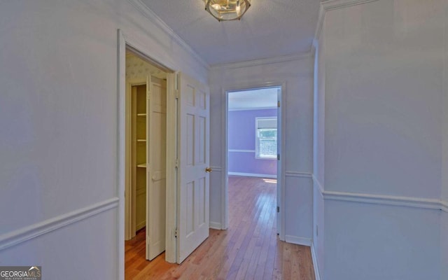 hall featuring light wood-type flooring and crown molding