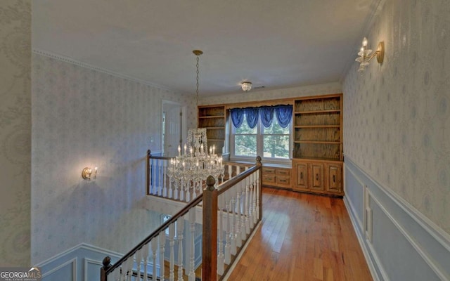 hall with wood-type flooring and a notable chandelier