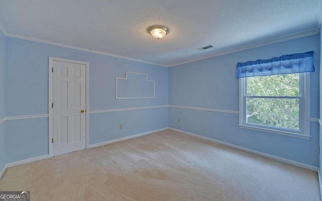 empty room featuring light carpet, a textured ceiling, and crown molding