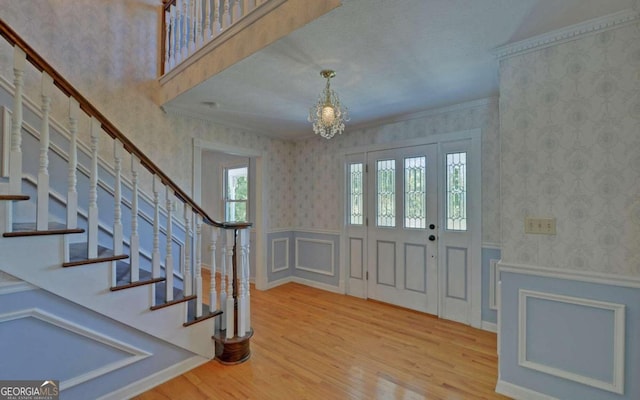 foyer entrance with hardwood / wood-style flooring and a chandelier