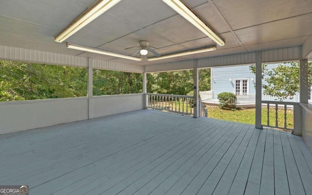 unfurnished sunroom featuring ceiling fan