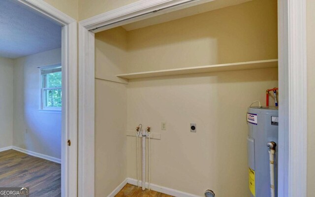 clothes washing area featuring wood-type flooring, electric water heater, hookup for a washing machine, and electric dryer hookup