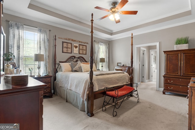 carpeted bedroom featuring ornamental molding, a tray ceiling, and ceiling fan