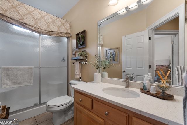 bathroom with tile patterned flooring, vanity, toilet, and an enclosed shower