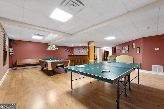 game room with billiards, a drop ceiling, and hardwood / wood-style floors