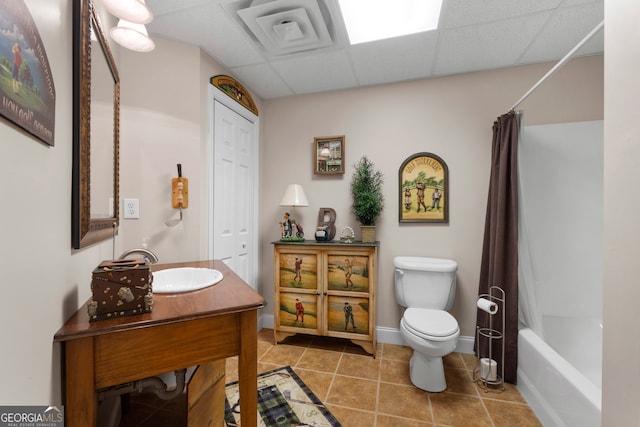 full bathroom with shower / bath combo, a paneled ceiling, tile patterned floors, vanity, and toilet