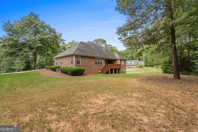 view of side of home with a wooden deck and a yard