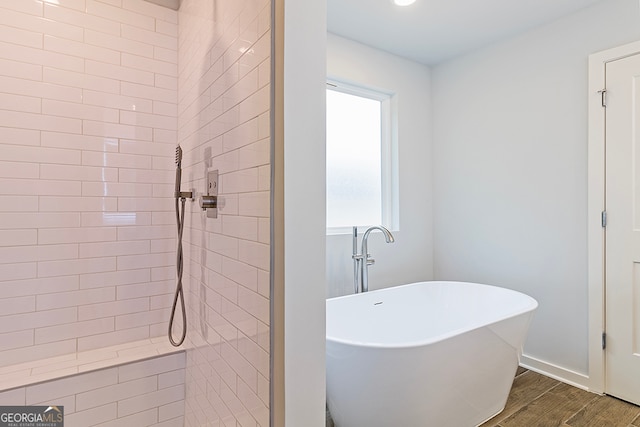 bathroom featuring plus walk in shower and wood-type flooring