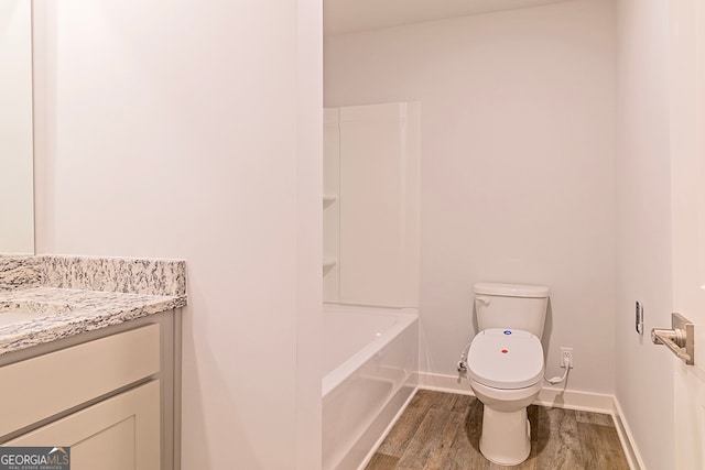 bathroom with wood-type flooring, vanity, and toilet