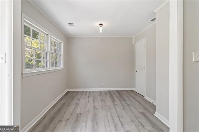 unfurnished room featuring ornamental molding and light hardwood / wood-style floors