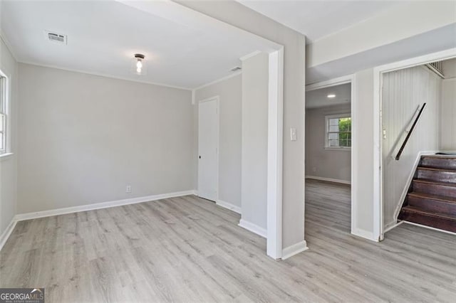 spare room with ornamental molding and light hardwood / wood-style flooring