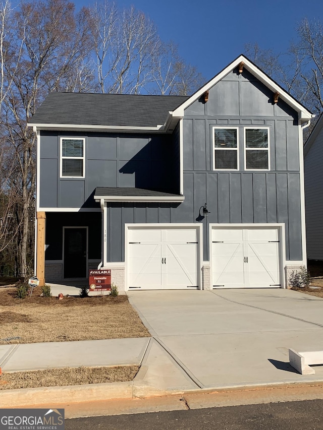 view of front of home featuring board and batten siding, driveway, and a garage