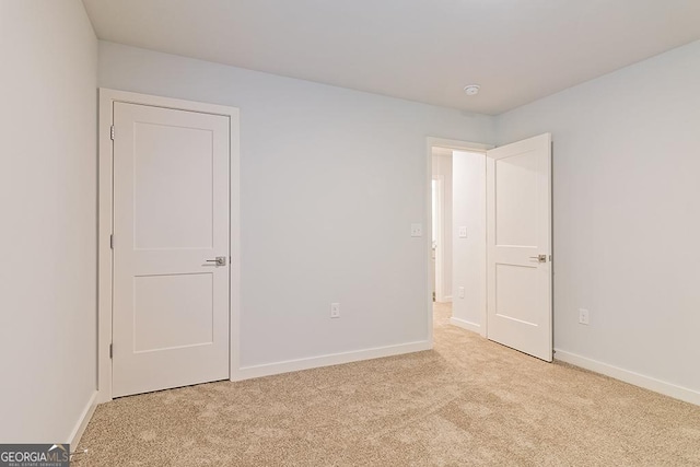 unfurnished bedroom with light carpet and baseboards