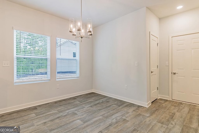 interior space featuring recessed lighting, light wood-style flooring, baseboards, and an inviting chandelier