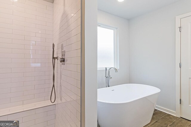 bathroom with a freestanding tub, a tile shower, and wood finished floors
