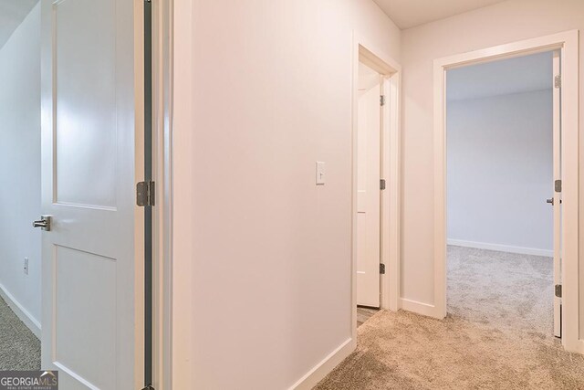 hall featuring carpet floors and baseboards