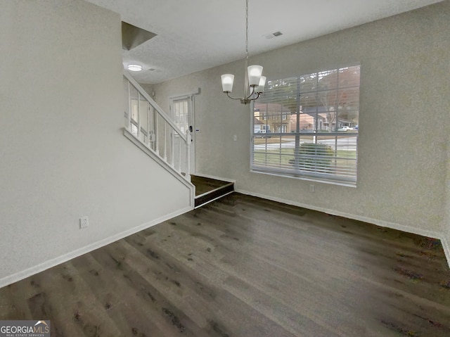 unfurnished dining area with a notable chandelier and dark hardwood / wood-style floors