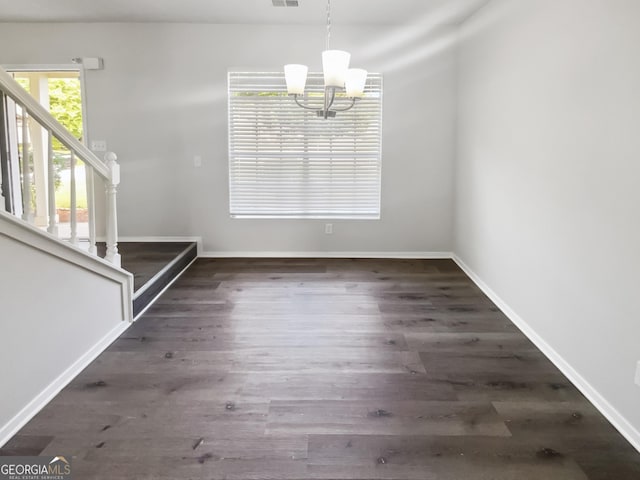 unfurnished dining area featuring stairs, a chandelier, wood finished floors, and baseboards