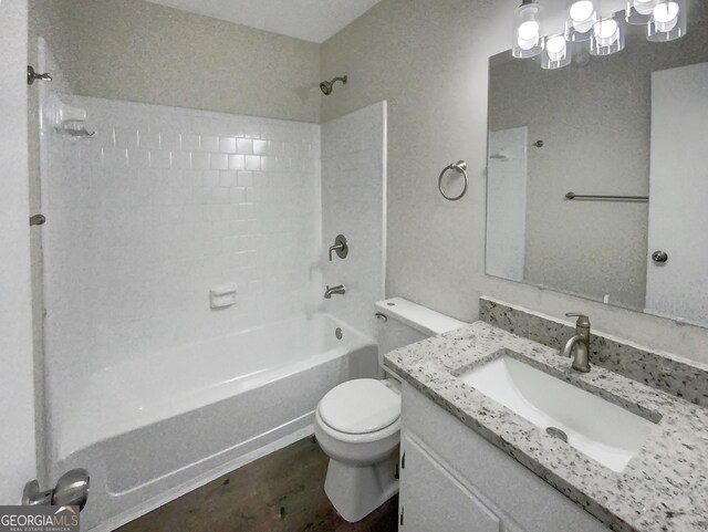 full bathroom with vanity, tiled shower / bath, and toilet