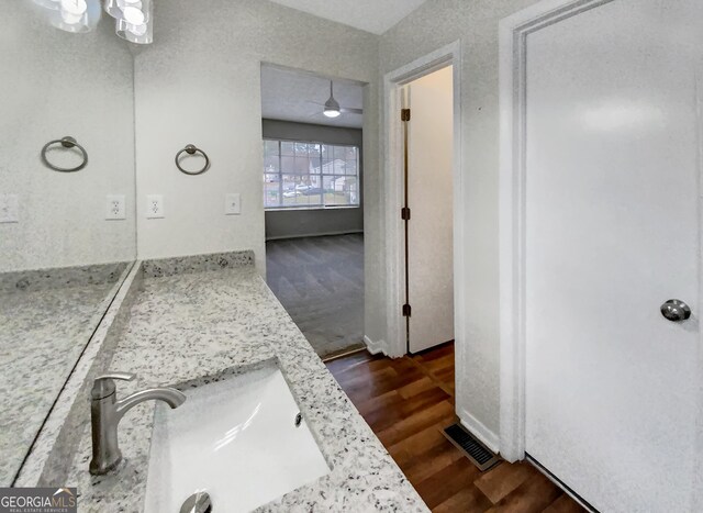 bathroom with vanity, ceiling fan, and hardwood / wood-style flooring