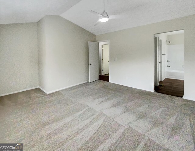 empty room with ceiling fan, carpet floors, and vaulted ceiling