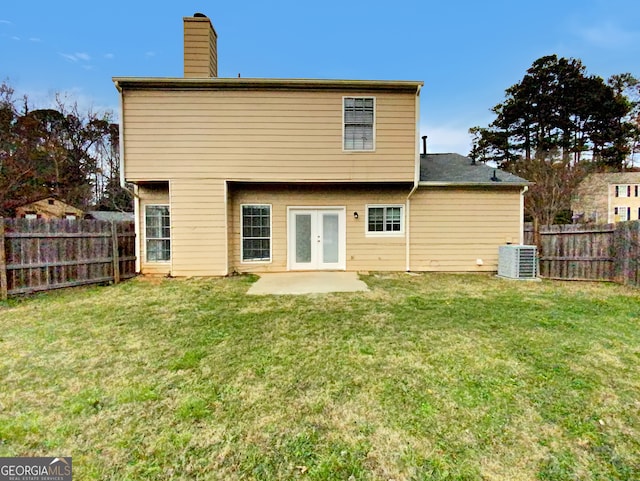 rear view of property featuring a patio, cooling unit, a yard, and french doors