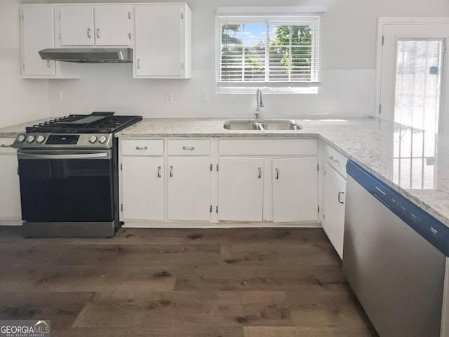 kitchen with stainless steel appliances, a sink, under cabinet range hood, white cabinetry, and dark wood-style floors