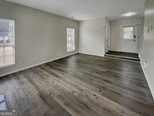 unfurnished living room featuring dark wood-type flooring