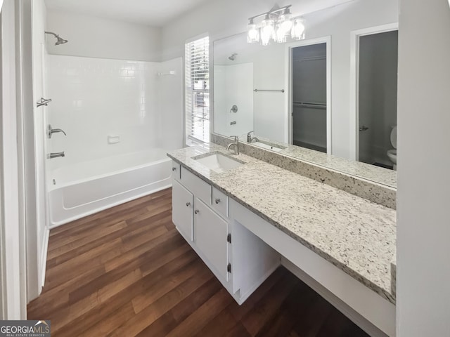 full bathroom with wood finished floors, toilet, vanity, bathing tub / shower combination, and a chandelier