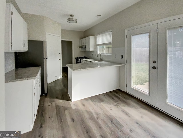 kitchen featuring white cabinetry, black range, light hardwood / wood-style flooring, french doors, and stainless steel fridge