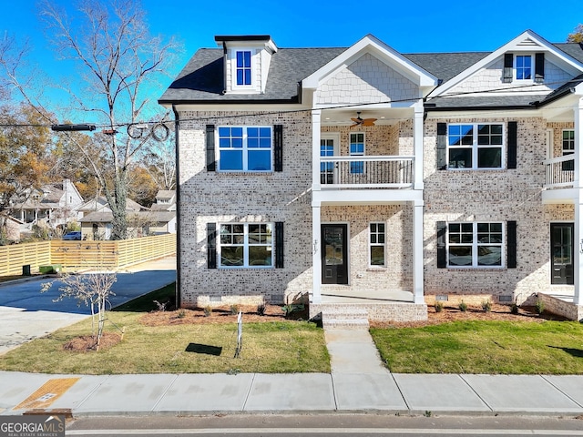 view of front of property with ceiling fan, a balcony, and a front yard