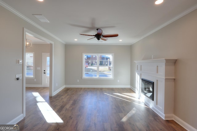 unfurnished living room featuring ornamental molding, ceiling fan with notable chandelier, and dark wood-type flooring