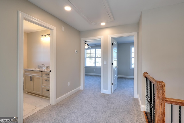 hallway featuring sink and light carpet