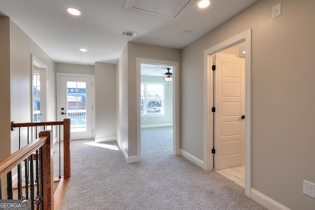 hall with light colored carpet