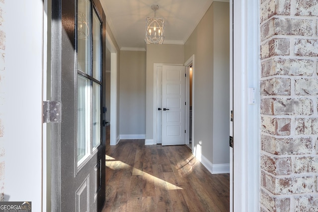 interior space featuring dark hardwood / wood-style floors, an inviting chandelier, and ornamental molding