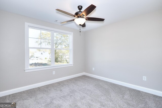 carpeted spare room with ceiling fan