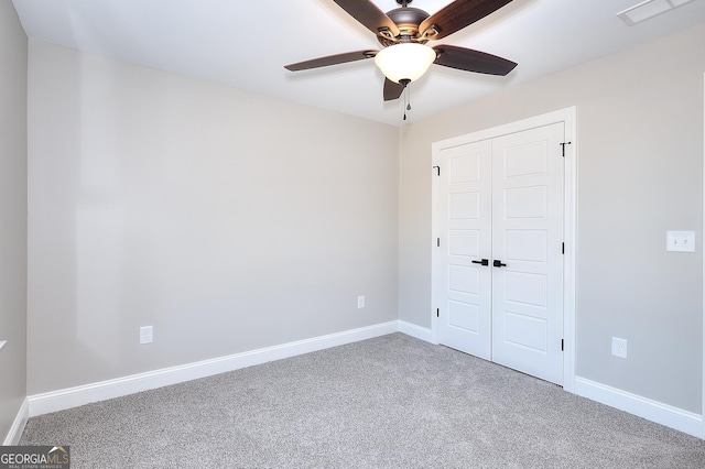 unfurnished bedroom with carpet, a closet, and ceiling fan