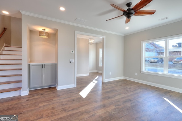 interior space featuring crown molding, dark wood-type flooring, and ceiling fan with notable chandelier