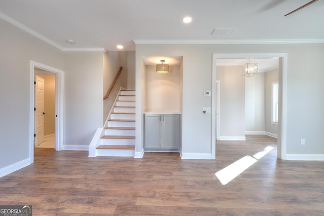 interior space with wood-type flooring, ornamental molding, and a notable chandelier